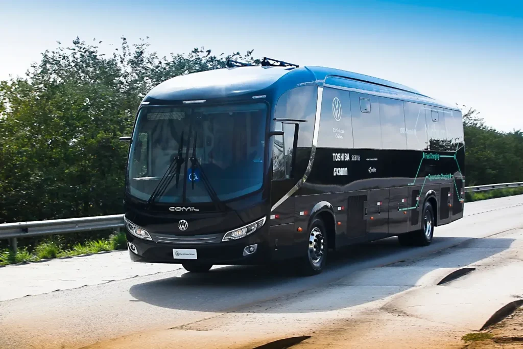 A Volkswagen Caminhões e Ônibus, em colaboração com CBMM e Toshiba, começou a testar um ônibus elétrico equipado com uma bateria de íons de lítio contendo nióbio. Essa inovação permite uma recarga completa em apenas 10 minutos, proporcionando operação contínua de 24 horas. Além disso, a bateria promete uma vida útil até três vezes maior que as convencionais. A tecnologia está em fase experimental e ainda precisa de mais tempo para avaliação econômica e ajustes antes da comercialização.